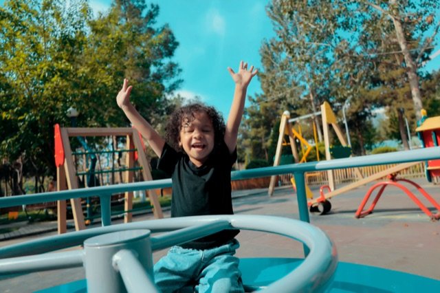 Niña disfrutando de un juego giratorio en un parque de Ingeniarte