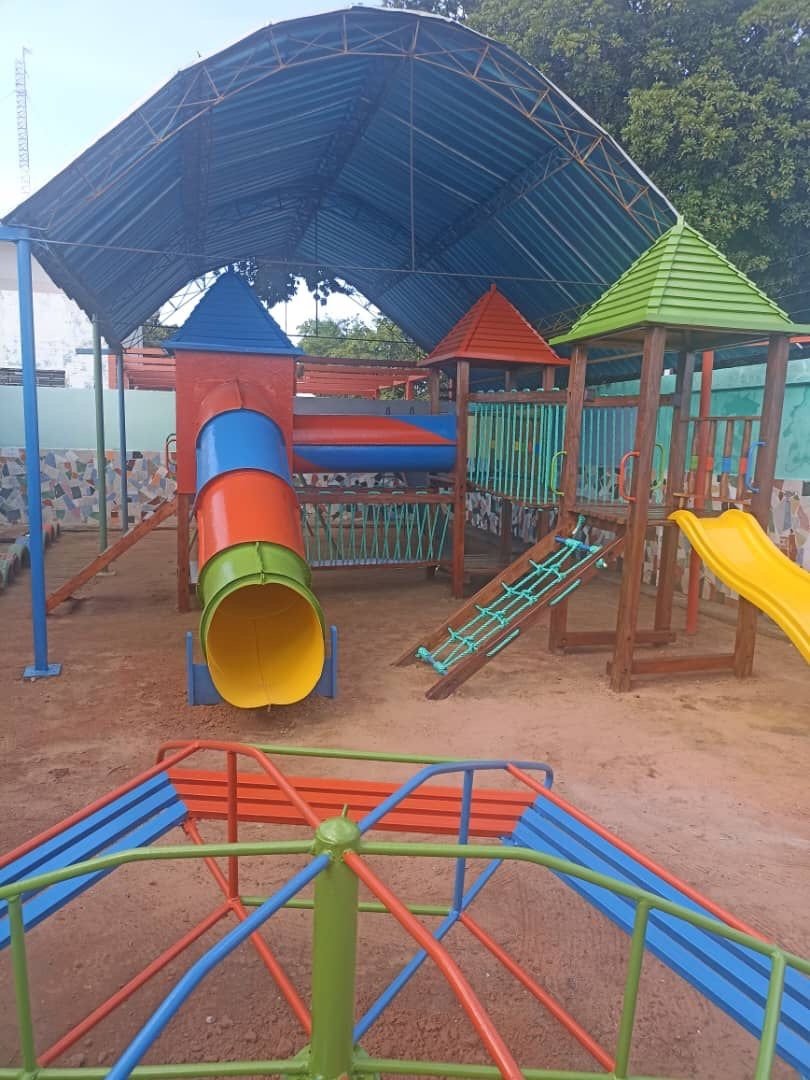Parque infantil techado con toboganes de colores en el Colegio Maracaibo