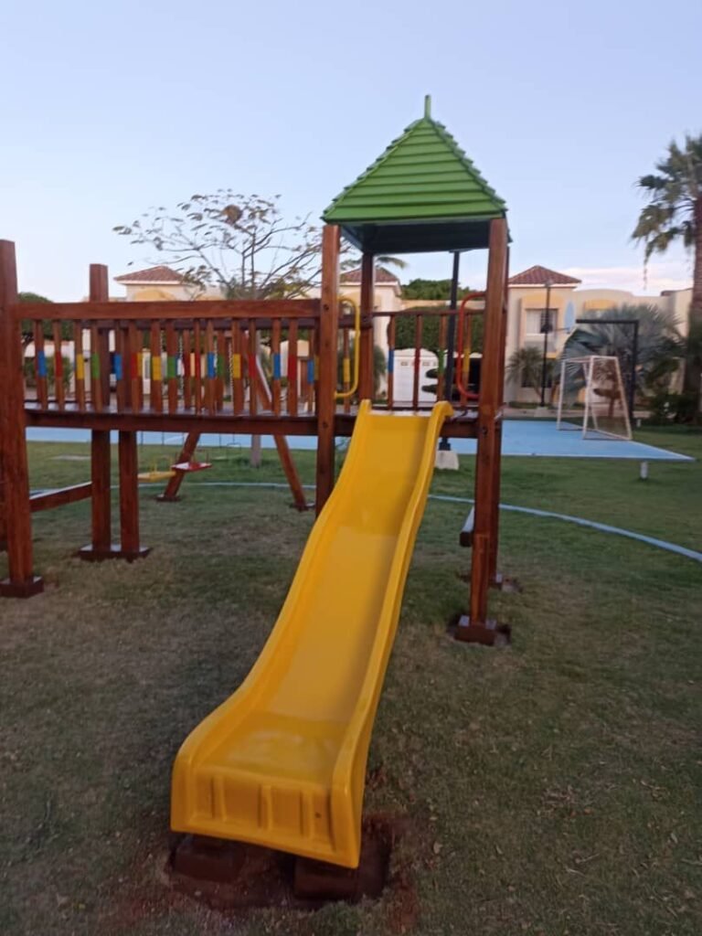 Parque infantil con tobogán amarillo instalado en la Residencia Bohío del Lago